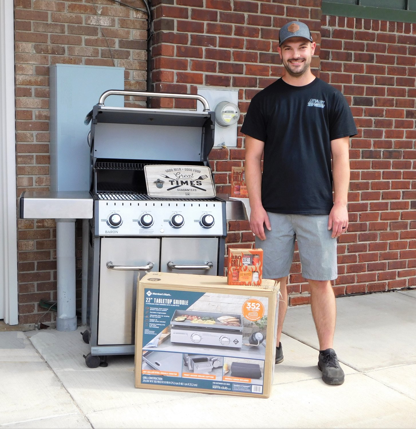 Grill Off 2nd and 3rd place winner Jerret Pratt stands with his prizes: a four burner Broil King Baron grill donated by Harrison Do-It Best Lumber and a Members Mark 22-inch tabletop griddle provided by Longer Table.
